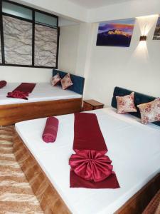 a bedroom with two beds with red bows on them at grace homestay in Darjeeling