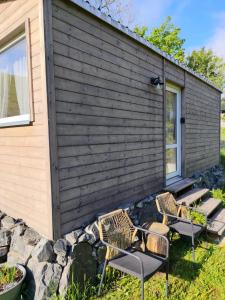 a tiny house with two chairs next to a building at Tinyhouse Cecilka in Ústí nad Orlicí