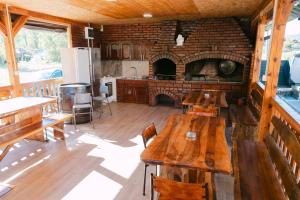 a kitchen with wooden tables and a brick fireplace at Apartmani Dejavu na Drini in Ljubovija