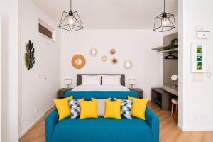 a bedroom with a blue couch with yellow pillows at Yellow Apartment in Bari