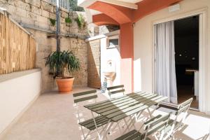 a patio with a table and chairs on a balcony at Yellow Apartment in Bari