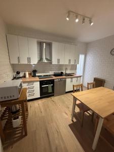 a kitchen with white cabinets and a wooden table at VUT TRINIDAD 3 dormitorio in La Guardia