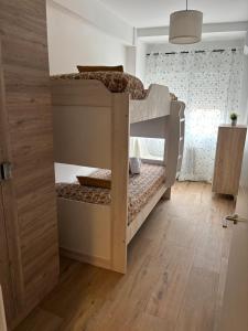 a bunk bed in a room with a wooden floor at VUT TRINIDAD 3 dormitorio in La Guardia