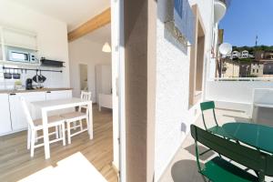 a kitchen and living room with a table and chairs at Velis - art & hospitality in Posada