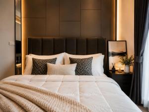 a bedroom with a large white bed with pillows at Ultra luxury Condo in Bangkok