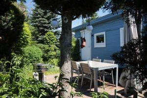 a table and chairs in front of a blue house at Glamping im Tiny House - nahe Dresden in Freital