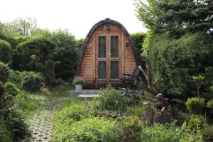 a small wooden cabin in the middle of a garden at Glamping im Tiny House - nahe Dresden in Freital +6 photos