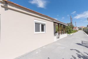 a white house with a long walkway at Pastida Olive Home in Pastida