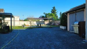 a gravel driveway with a building and a yard at Maison Galland in Lapalisse