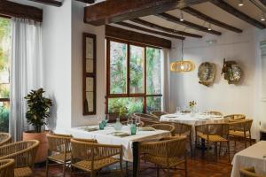 a restaurant with white tables and chairs and windows at Hotel Nou Romà in Denia