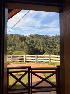 a view of a fence and a field from a window at Chalé Recanto do Quilombo - MV in Camanducaia