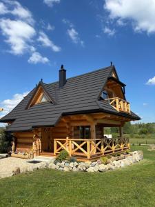 a large log cabin with a black roof at Domek z Sercem in Pieniążkowice