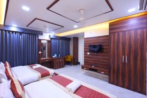 a hotel room with two beds and a television at The Crown Hotel Agra near Taj Mahal in Agra