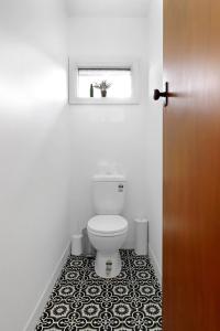 a bathroom with a toilet with a black and white tile floor at Retro Retreat in Highton +20 photos