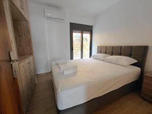 a bedroom with a large bed with two towels on it at Episkopos Escape in Nikiana