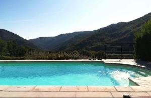 a swimming pool with mountains in the background at La Vie en Le Reve kamers, chambre d'hôtes in Cassaniouze