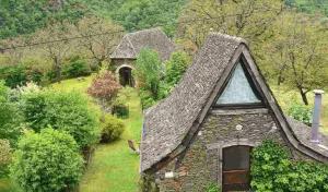 an old stone house with a pointed roof at La Vie en Le Reve kamers, chambre d'hôtes in Cassaniouze +5 photos
