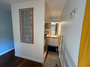 a hallway with a bathroom with a sink and a mirror at La Vie en Le Reve kamers, chambre d'hôtes in Cassaniouze