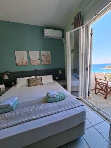 a bedroom with a bed with a view of the ocean at Kini Bay in Kini
