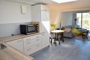 a kitchen with a tv and a living room at Eb & Vloed in Petten