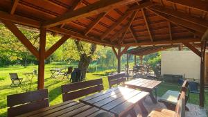 a picnic table and chairs under a wooden pavilion at Park Apartman in Sály