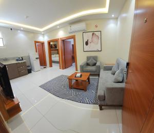 a living room with a couch and a coffee table at المهيدب 3 للشقق المخدومة - اقتصادى in Buraydah
