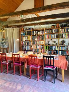a table in a library with chairs and books at Park Apartman in Sály