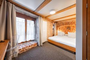 a bedroom with a bed and a brick wall at Rixwell Old Riga Palace Hotel in Riga +55 photos