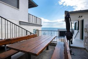 a wooden bench on a balcony with an umbrella at House Dunja in Omiš