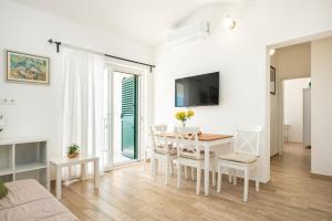 a white living room with a table and a dining room at House Dunja in Omiš