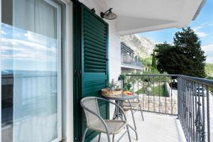 a patio with a table and chairs on a balcony at House Dunja in Omiš