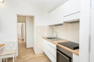 a kitchen with white cabinets and a sink at House Dunja in Omiš