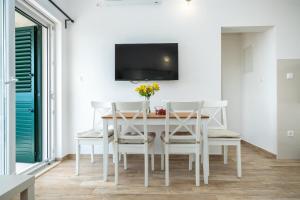 a dining room with a white table and chairs at House Dunja in Omiš +44 photos