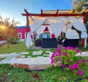 a garden with a tent and flowers in the grass at Ape Rossa in Castellana Grotte