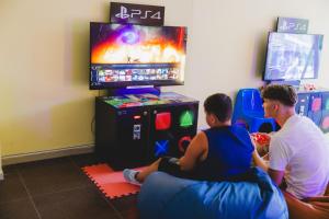 two people sitting on the floor playing a video game at Sun Palace Hotel - All Inclusive in Sunny Beach