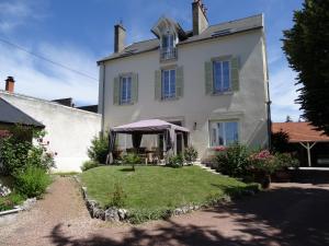 une grande maison blanche avec une tente dans la cour dans l'établissement Maison Gille, à Nuits-Saint-Georges