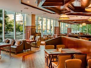 a restaurant with tables and chairs and windows at Novotel Ulaanbaatar in Ulaanbaatar