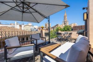 a patio with chairs and an umbrella on a roof at Casa del Call in Palma de Mallorca