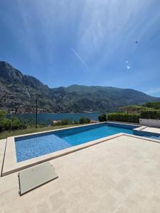a swimming pool with a view of the mountains at Luxury Studio Apartment with Sea View & Heated Pool in Kotor