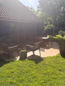 a patio with benches and a table in the grass at Au pied de Lille, parking privé inclus in Lille