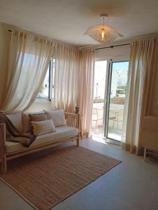 a living room with a couch and a large window at Apartamentos Eugenio by Formentera Passport in La Savina