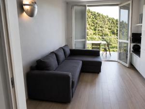 a living room with a couch and a large window at BellaVista - Vallecrosia in Vallecrosia