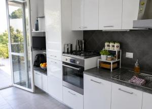 a kitchen with white cabinets and a stove at BellaVista - Vallecrosia in Vallecrosia