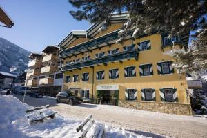 a yellow building with a car parked in front of it at Postresidenz in Mayrhofen