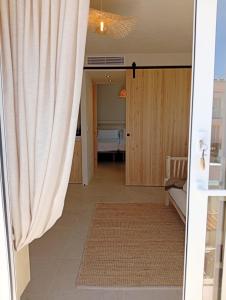 a door leading into a room with a curtain at Apartamentos Eugenio by Formentera Passport in La Savina