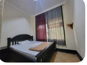 a small bedroom with a bed and a window at Iringa Hillside backpackers in Iringa