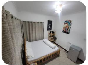 a small bedroom with a bed and a window at Iringa Hillside backpackers in Iringa +6 photos