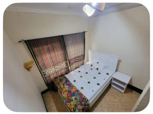 a small bedroom with a bed and a chair at Iringa Hillside backpackers in Iringa