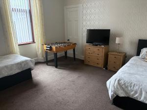 a bedroom with a table with a chess board on it at Preston Villa, spacious ground floor apartment in Buckie