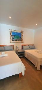 a bedroom with two beds and a painting on the wall at Pili Beach Resort Agmanic in Santa Fe +56 photos